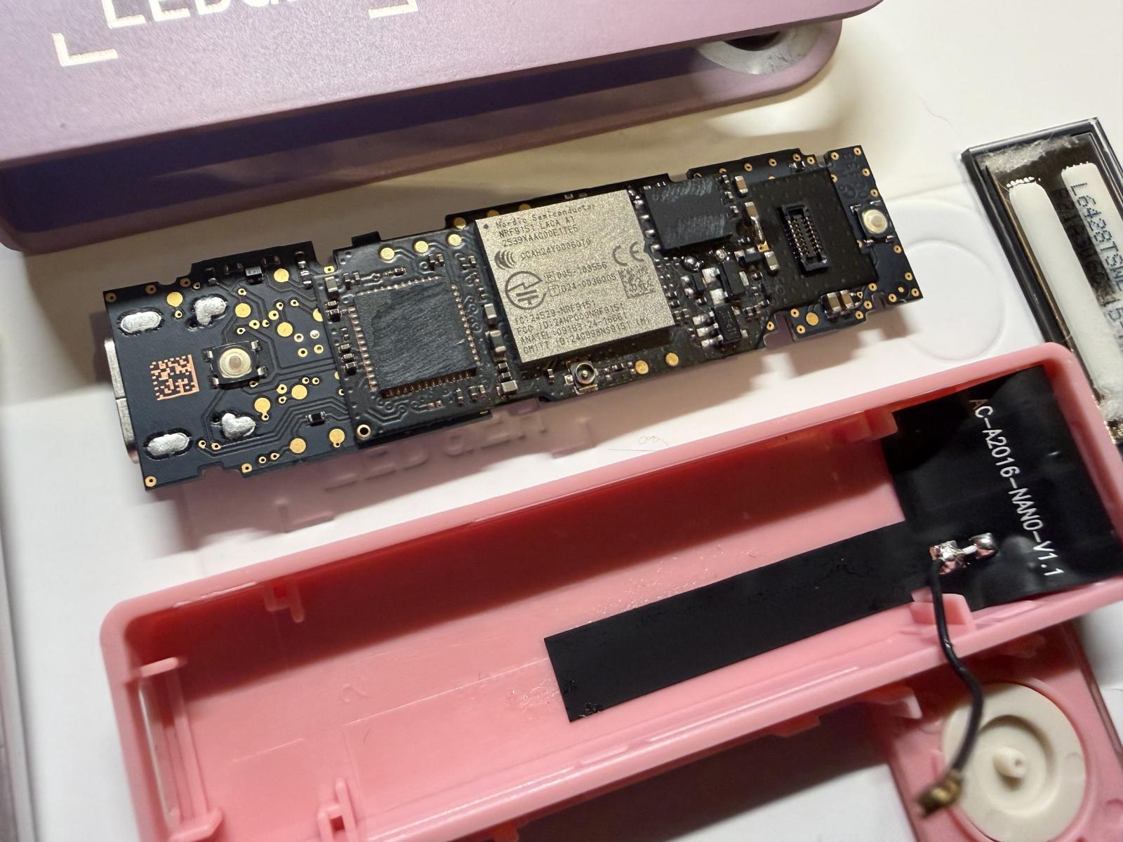 Placa del implante de hardware instalada bajo la pantalla de un Ledger Nano X, analizada por Mark Karpelès