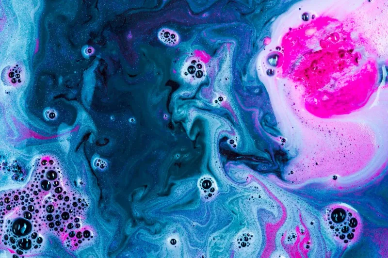 Imagen abstracta de pintura fluida en tonos turquesa y rosa con burbujas