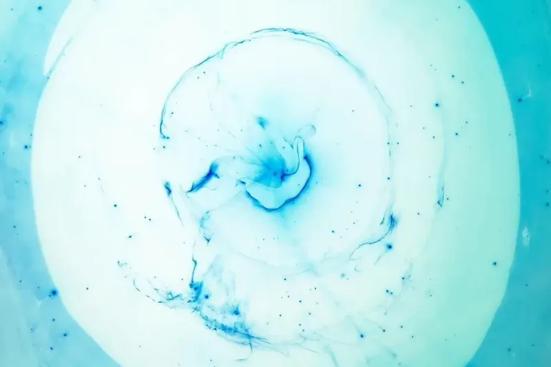 Remolino de tinta azul difuminándose en el agua a modo de imagen conceptual