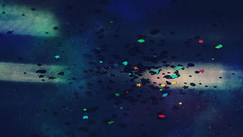 Fotografía abstracta azul oscuro con confeti de colores en forma de estrellas y corazones