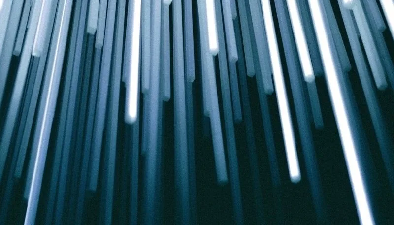 Fotografía abstracta de haces de luz verticales en tonos azules y grises
