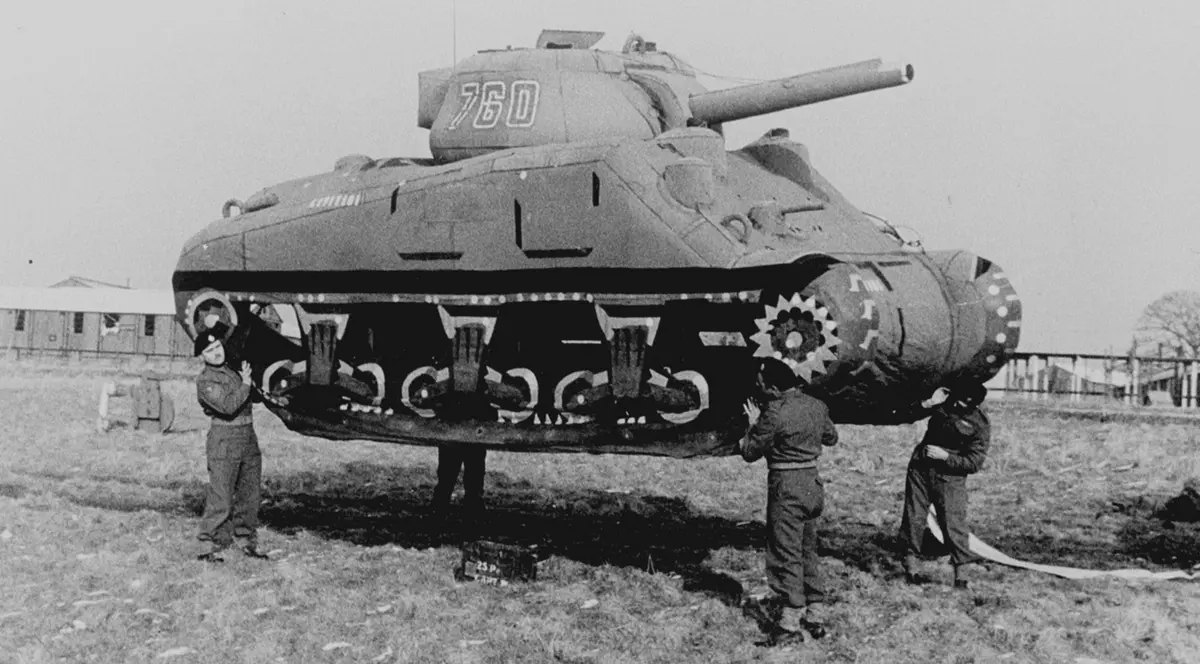 Fotografía en blanco y negro de un tanque inflable señuelo sostenido por soldados