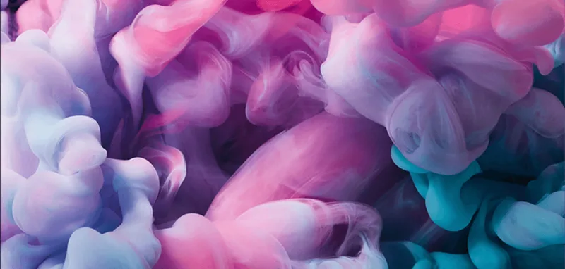 Primer plano de humo de colores rosa, morado y azul entremezclados