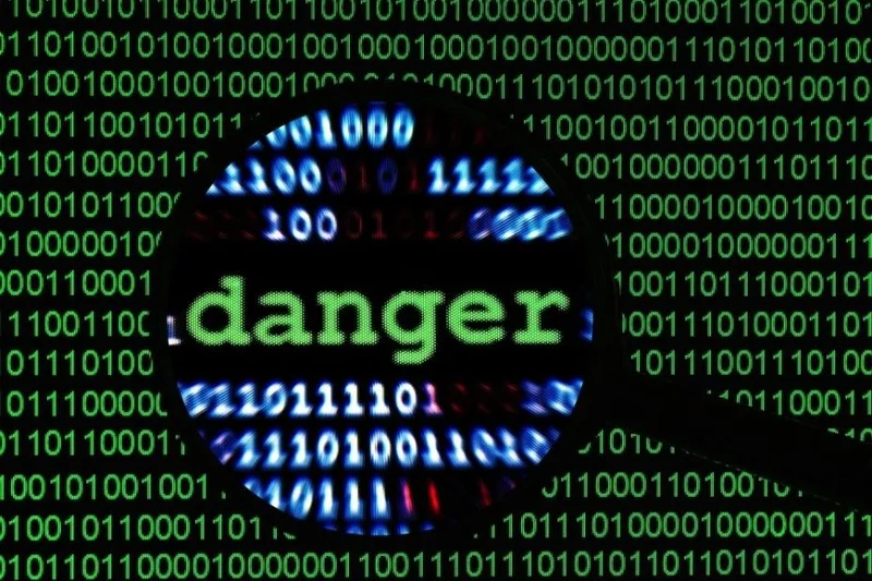 Lupa ampliando código binario donde resalta la palabra danger en pantalla